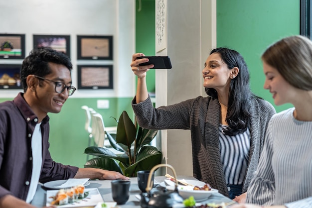 Foto indische influencer-frau, die ein foto von abendessen auf dem orientalischen tisch macht