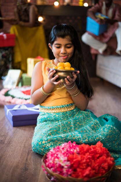 Indische Kinder feiern Diwali, Deepawali, Bhai Dooj oder Rakhi oder Raksha Bandhan mit Blumenrangoli, Geschenken, Diya