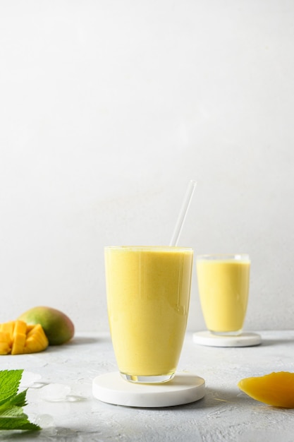 Indische Mango oder Kurkuma Lassi auf grauem Hintergrund