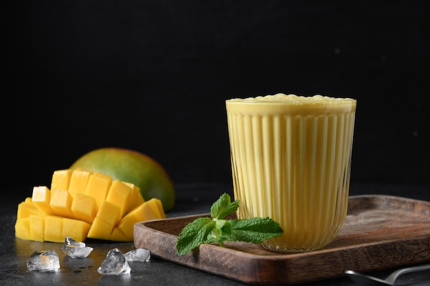 Indische Mango oder Kurkuma Lassi auf schwarzem Hintergrund