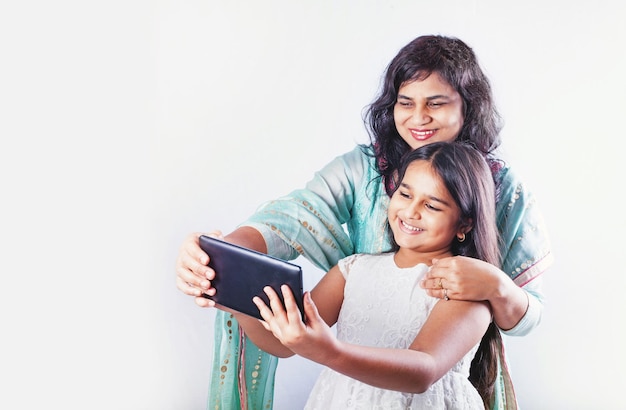 Indische Mutter und Tochter machen Selfie mit Tablet