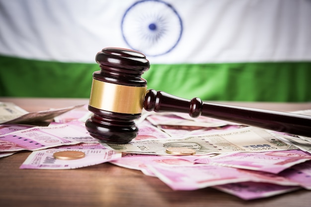 Indische neue Rupie-Währungsnoten mit Holzhammer, der das Finanzrecht in Indien mit Trikolore im Hintergrund zeigt