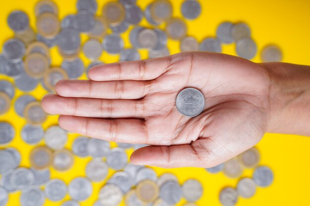 Indische Rupien-Münze in Frauenhand halten
