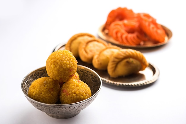 Indische süße Jalebi oder Imarti, Laddu und Gujiya serviert zusammen auf weißem Hintergrund oder mit Geschenken. Selektiver Fokus