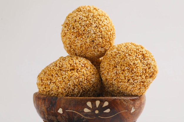 Indische Süßigkeit für traditionelles Festival Makar Sankranti: Rajgira Laddu aus Amaranth-Samen in Schüssel auf weißem Hintergrund.