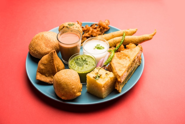 Indische Tee-Snacks in der Gruppe umfassen Veg Samosa, Kachori, Kachaudi, Aloo Bonda, Khaman Dhokla, Brot, Zwiebeln, Chili und Moong Pakora, Pakoda, Bhaji, Bhajji, Bhajiya, Bajji mit Saucen