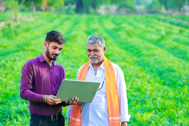 indischer Agronom mit Landwirt am Feld