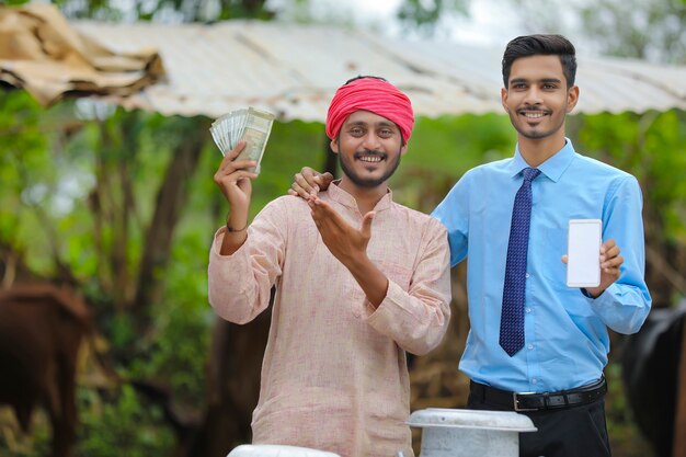 Indischer Agronomen zeigt Smartphone-Bildschirm mit Landwirt