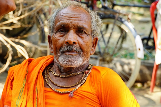 Indischer alter glücklicher Mann im Dorf und Blick auf die Kamera