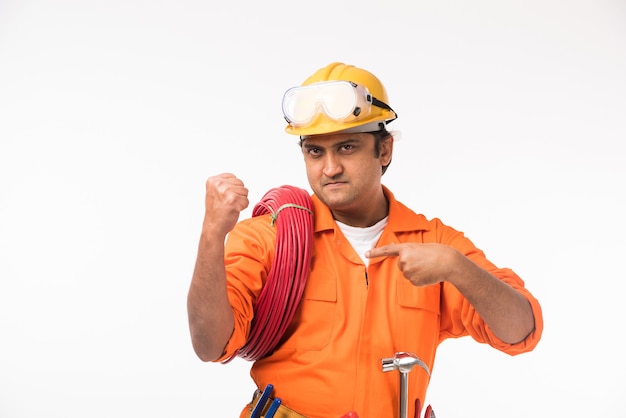Indischer asiatischer gutaussehender Elektriker oder Ingenieur in Aktion mit gelbem Sicherheitshut isoliert