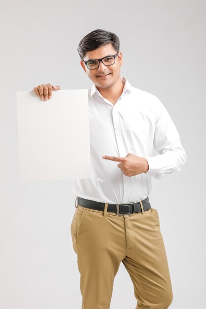 Indischer asiatischer junger Mann, der leeres Schild zeigt