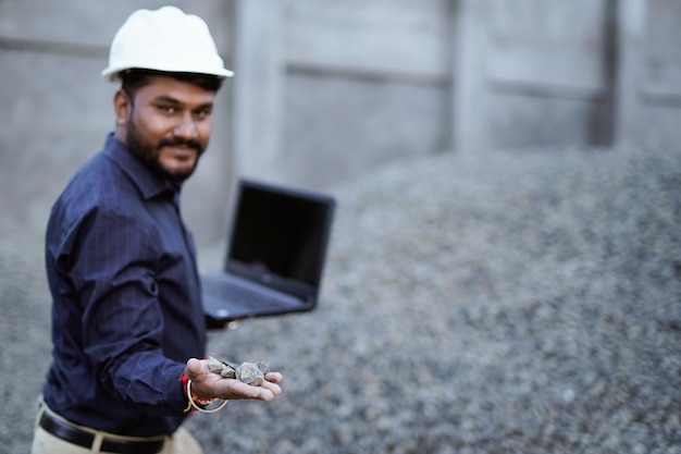 Indischer Bauingenieur prüft die Schotterqualität