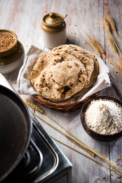 Indischer Chapati oder Fulka oder Gehu Roti mit Weizenkörnern im Hintergrund. Es ist ein gesundes, ballaststoffreiches traditionelles nord- oder südindisches Essen, selektiver Fokus