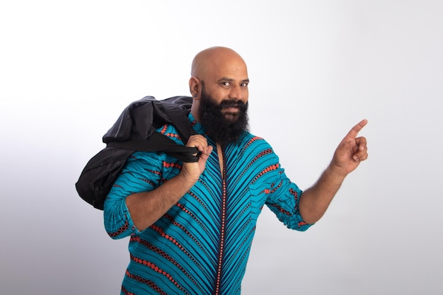 Indischer gesunder Mann mittleren Alters, der eine Tasche hält und mit einer Hand zeigt