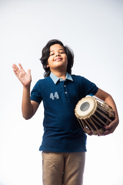 Indischer kleiner Junge, der Tabla-Musikinstrument spielt. Es ist ein klassisches Hindustani-Instrument