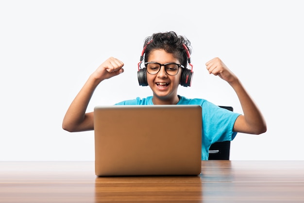 Indischer männlicher Syudent oder Kind, das online mit Laptop studiert. Asiatisches Kind, das eine Online-Schule mit Computer besucht