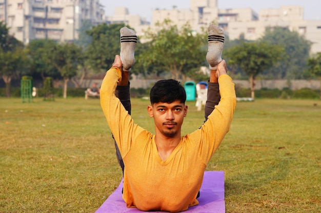 Indischer Mann, der Yoga-Asanas im Park macht