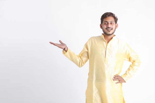 Indischer Mann in traditioneller Kleidung und aufgeregtem Ausdruck auf weißer Wand
