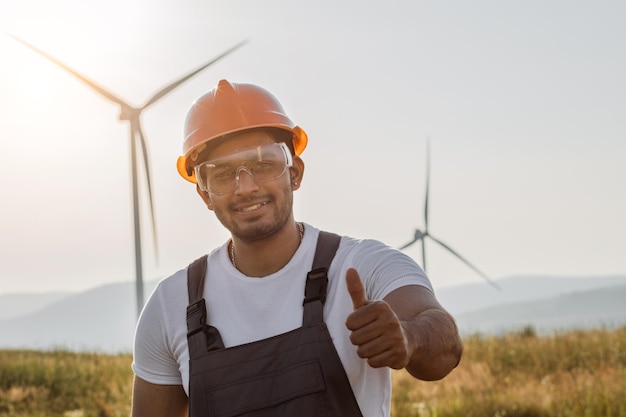 Indischer Mann in Uniform auf Farm mit Windmühlen