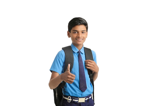 Indischer Schuljunge, der auf weißem Hintergrund steht