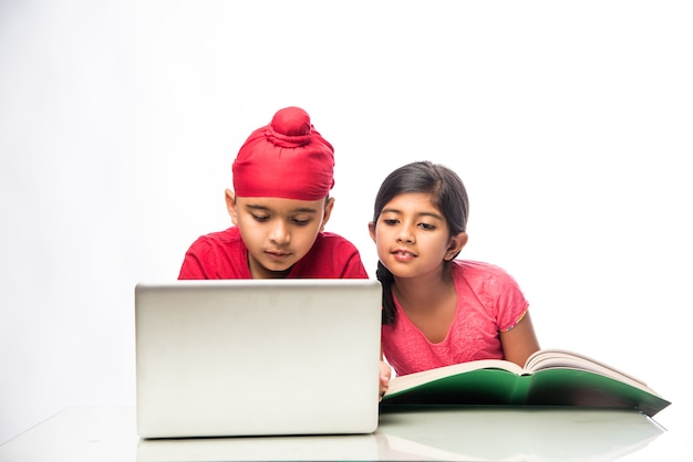 Indischer Sikh Punjabi Junge und Mädchen studieren mit Büchern und Laptop am Arbeitstisch