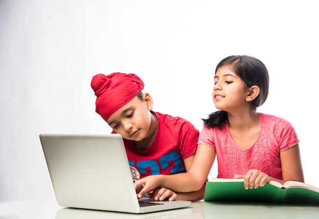 Indischer Sikh Punjabi Junge und Mädchen studieren mit Büchern und Laptop am Arbeitstisch