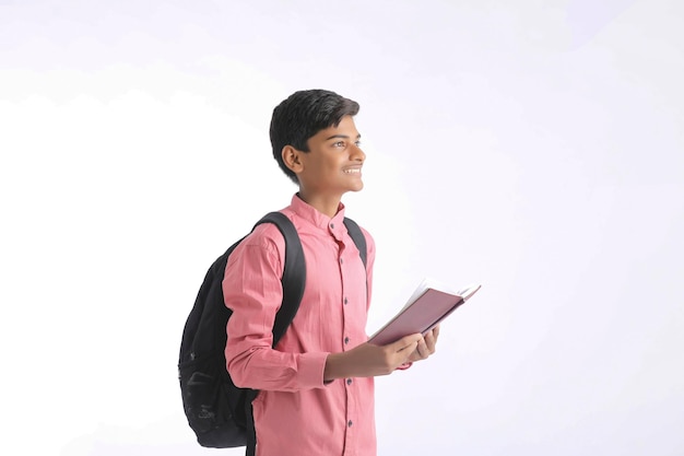 Indischer Student, der in der Hand Tagebuch auf weißem Hintergrund hält
