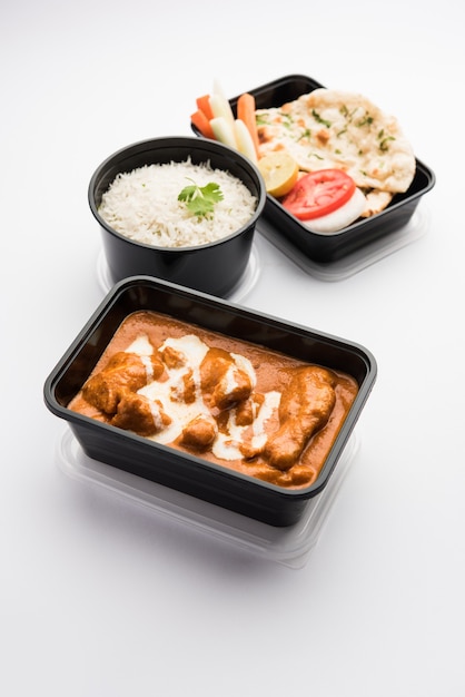 Indisches Butter-Hühnchen-Curry-Gericht, serviert in einem schwarzen Plastikbehälter für die Lieferung von Lebensmitteln nach Hause