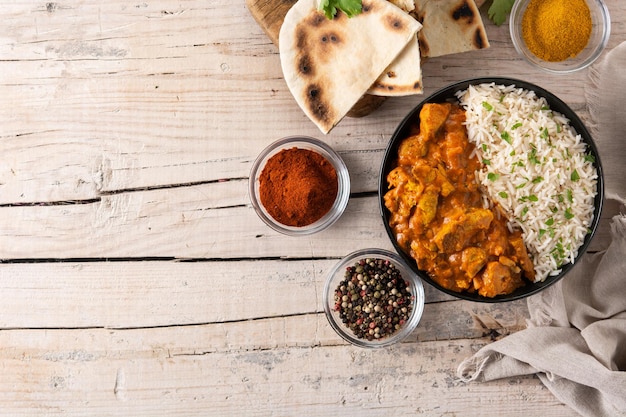 Indisches Butterhuhn in schwarzer Schüssel auf Holztisch