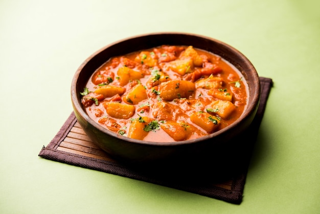 Indisches Essen - Aloo Curry Masala. Kartoffel gekocht mit Gewürzen und Kräutern in einem Tomatencurry. serviert in einer Schüssel über stimmungsvollem Hintergrund. selektiver Fokus