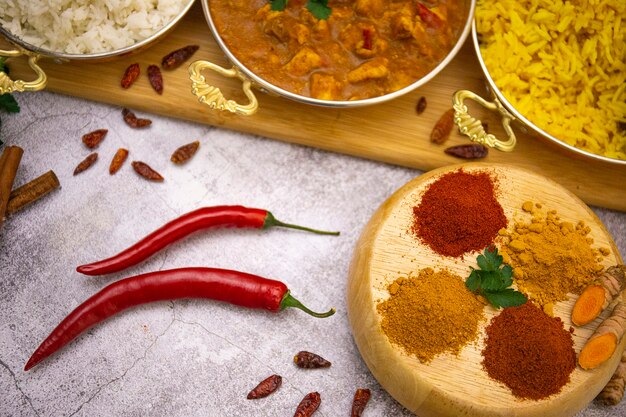 Indisches Essen. Curryhuhn in Tomatensauce mit weißem und gelbem Reis, Gewürze: Curry, Kurkuma, heißer und milder Paprika