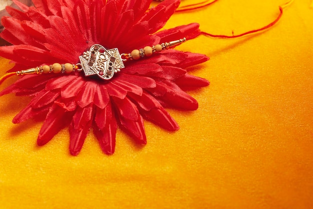 Indisches Festival Raksha Bandhan Ein traditionelles indisches Armband auf gelbem Hintergrund