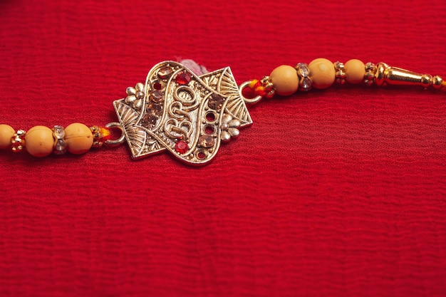 Indisches Festival Raksha Bandhan Ein traditionelles indisches Armband auf rotem Grund