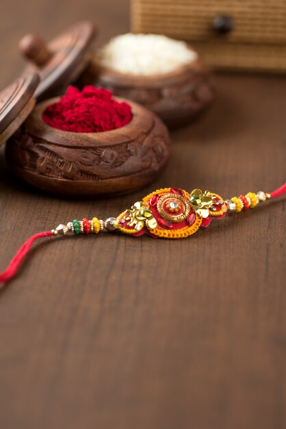 Indisches festival: raksha bandhan feier mit einem eleganten rakhi, reiskörnern und kumkum. ein traditionelles indisches armband, das ein symbol der liebe zwischen brüdern und schwestern ist.