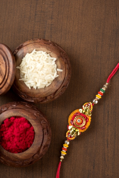 Indisches Festival: Raksha Bandhan mit elegantem Rakhi, Reiskörnern und Kumkum. Ein traditionelles indisches Armband, das ein Symbol der Liebe zwischen Brüdern und Schwestern ist.