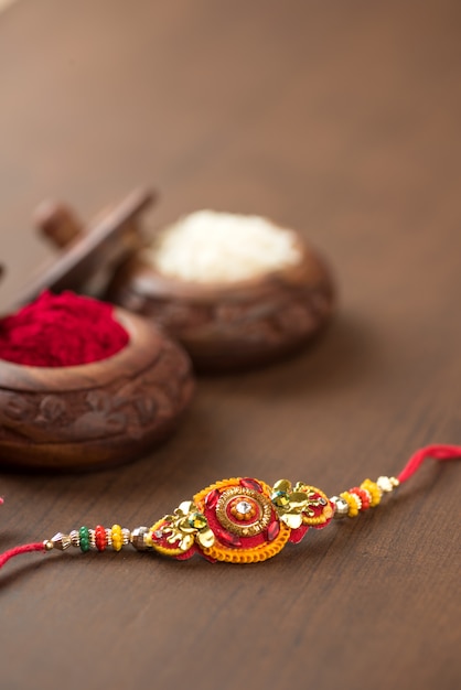 Indisches Festival: Raksha Bandhan mit elegantem Rakhi, Reiskörnern und Kumkum. Ein traditionelles indisches Armband, das ein Symbol der Liebe zwischen Brüdern und Schwestern ist.