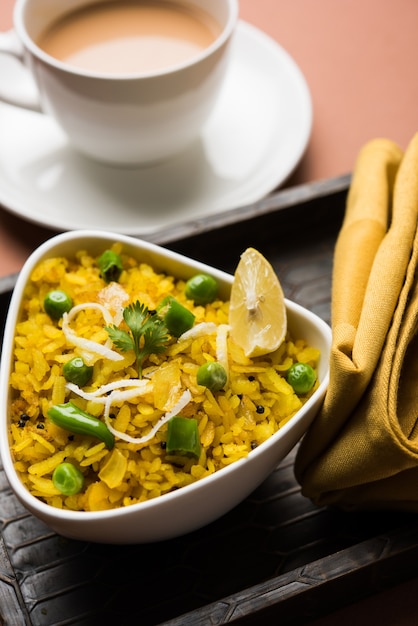 Indisches Frühstücksgericht Poha Auch bekannt als Pohe oder Aalu Poha, bestehend aus geschlagenem Reis oder abgeflachtem Reis. Die Reisflocken werden in Öl mit Gewürzen leicht angebraten und mit heißem Tee serviert