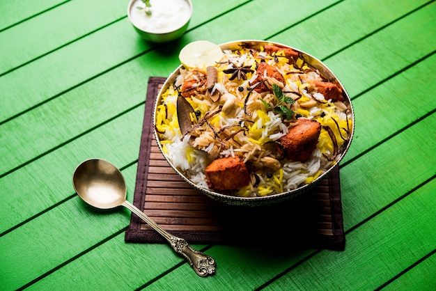 Indisches Hühnchen Tikka Biriyani serviert in einer Schüssel mit Joghurt