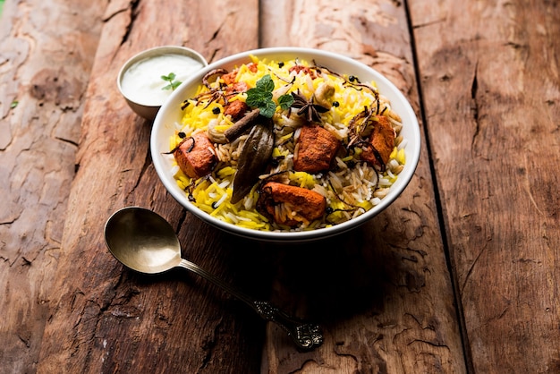 Indisches Hühnchen Tikka Biriyani serviert in einer Schüssel mit Joghurt