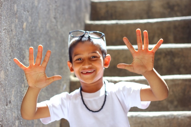Indisches Kind, das zehn Finger zeigt