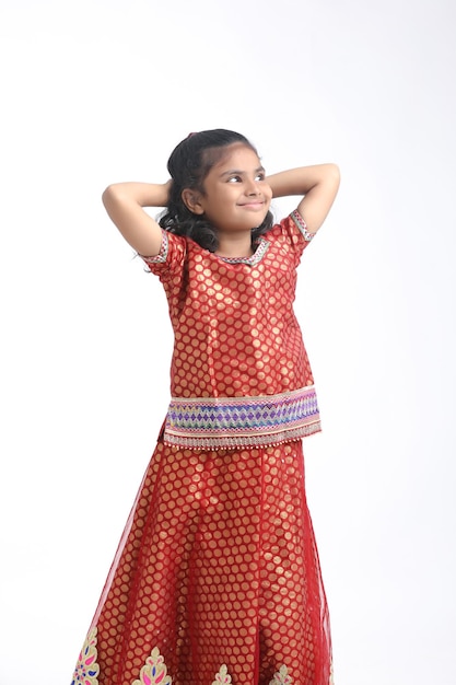 Indisches kleines Mädchen in traditioneller Kleidung und mit Ausdruck auf weißem Hintergrund