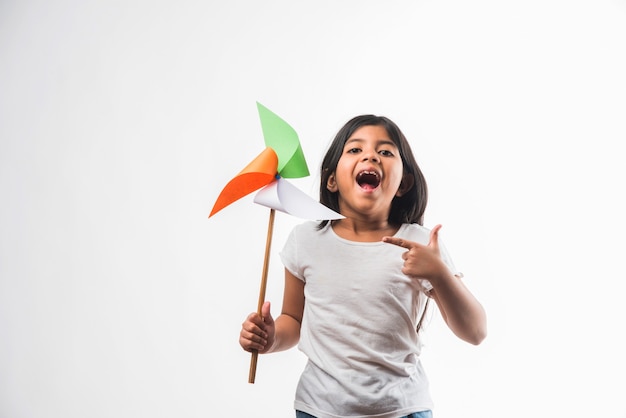 Indisches Mädchen mit Papierwindmühlenspielzeug aus Trikolore oder indischen Flaggenfarben. Geeignet für Happy Independence Day oder Republic Day Gruß.