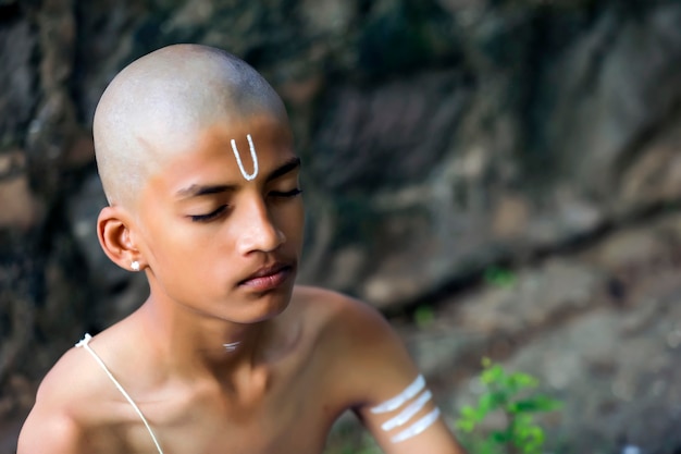 Foto indisches priesterkind, das meditation tut