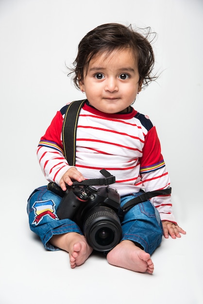 Indisches süßes kleines Baby oder Kleinkind oder Kleinkind mit DSLR-Kamera, möchte Fotograf werden