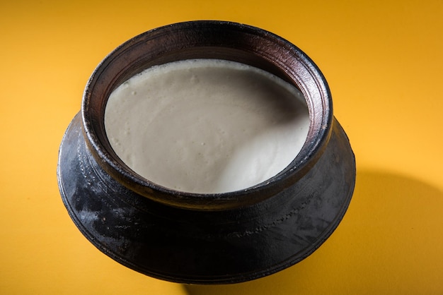Indisches süßes Lassi aus Milch, Quark, Zucker und Salz gemischt mit Eiswürfeln, serviert in einem Jumbo-Stahlglas, zubereitet im traditionellen Tontopf
