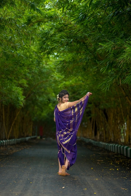 Indisches traditionelles schönes junges Mädchen im Saree, das draußen aufwirft