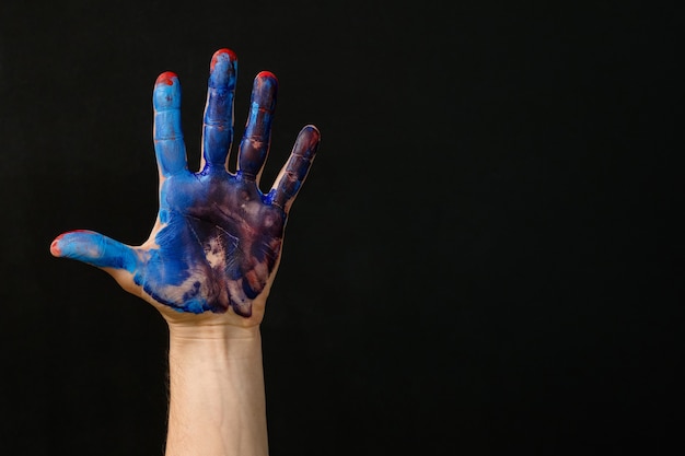 Individualität und Identität. Hand mit rotblauer Farbe verschmiert. Kunst Hobby Lebensstil Beruf. Kreative Aktivität und Therapie.