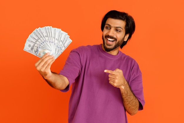 Indivíduo indiano emocional que guarda o dinheiro na mão