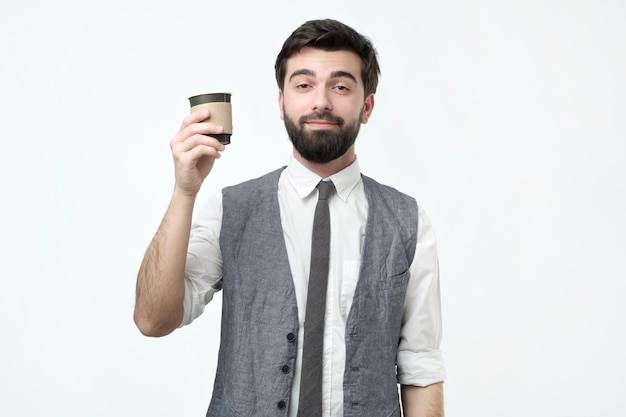 Individuo soñoliento que sostiene una taza de café