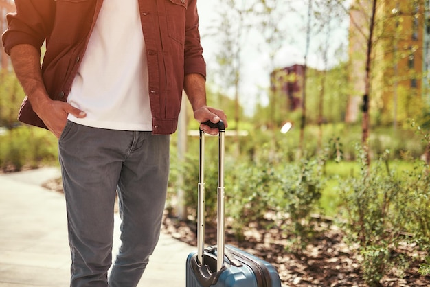 Indo para o aeroporto foto recortada de um homem em roupas casuais puxando sua bagagem